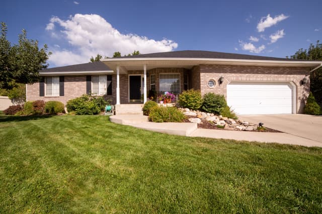 Single-story brick ranch home with landscaped front yard