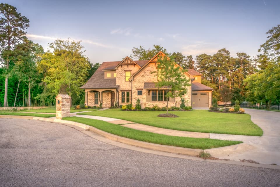 Stone suburban home exterior with landscaped front yard