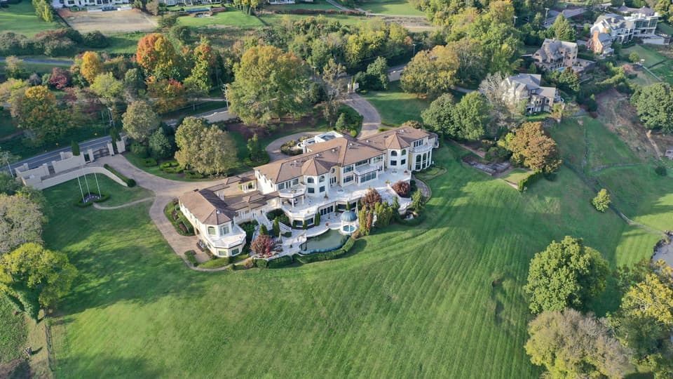 Aerial view of a large estate property with landscaped grounds